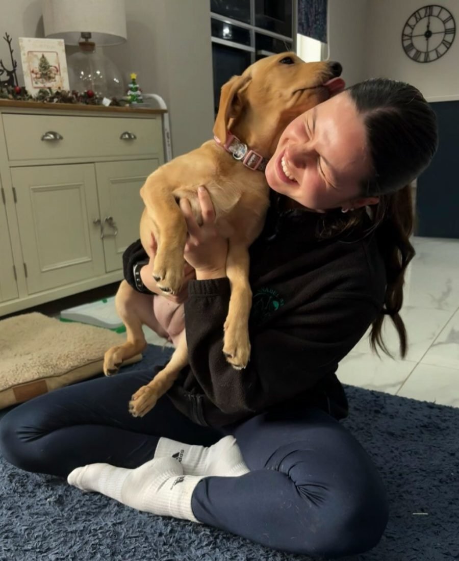 Annabel hugging a young Labrador